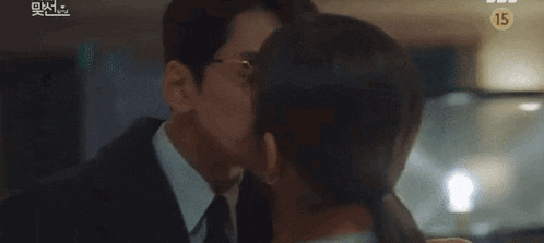 a man and a woman are kissing each other .