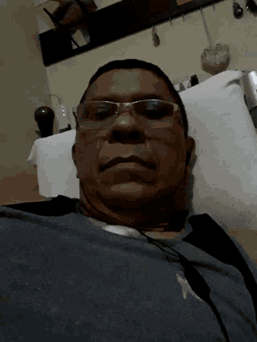 a man wearing glasses and headphones is laying on a bed
