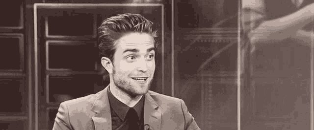 a man in a suit and tie is making a funny face .
