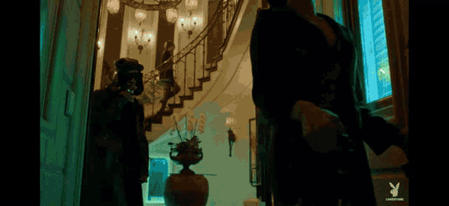 a man in a mask is walking down a set of stairs in a house .