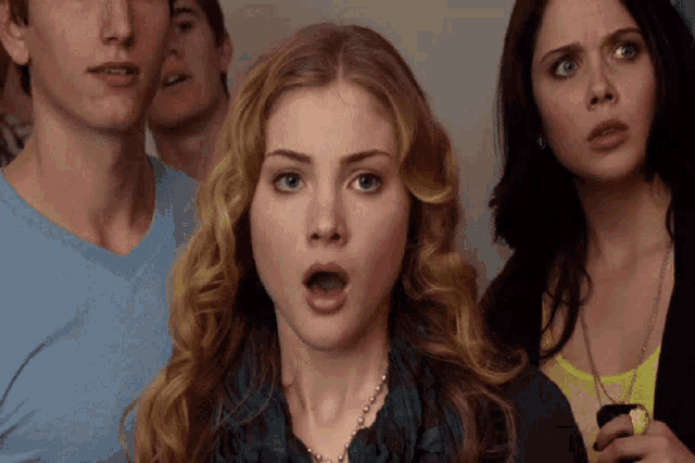 a woman with a surprised look on her face is surrounded by people