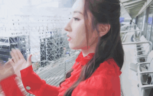a woman in a red dress looks out of a window