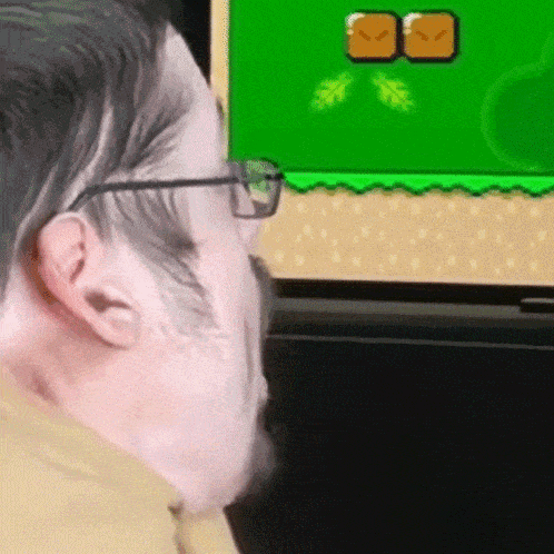 a man wearing glasses is playing a video game on a green screen