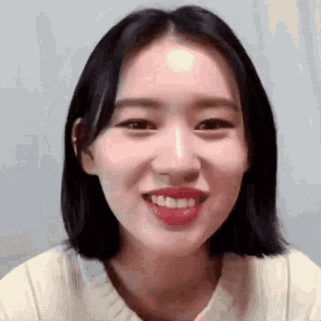 a close up of a woman 's face with her mouth open and a smile on her face .