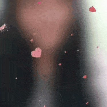 a close up of a person 's face with petals falling in the shape of a heart