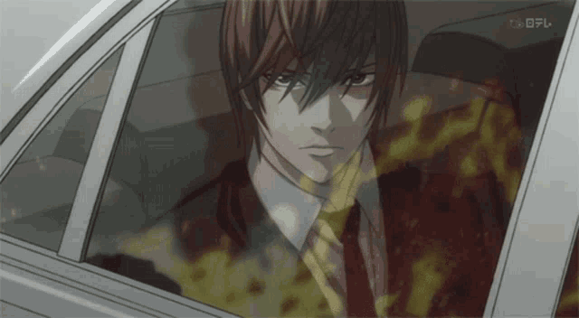 a man in a suit and tie is sitting in a car with a foreign language written on the bottom right corner