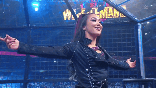 a woman in a black leather jacket is standing in front of a sign that says wrestlemania .