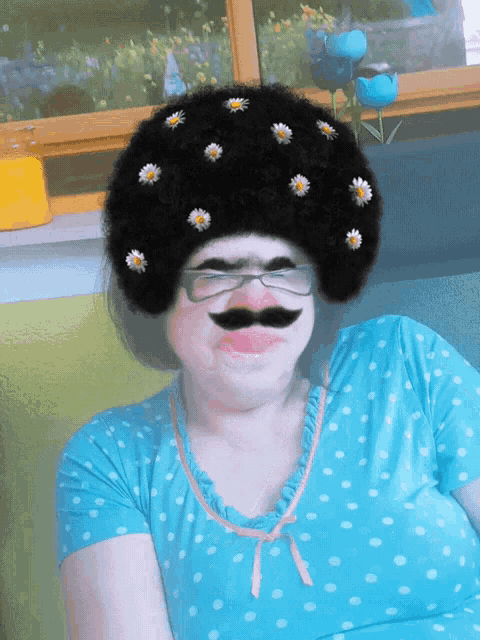 a woman in a blue polka dot shirt has a fake mustache and glasses on her face