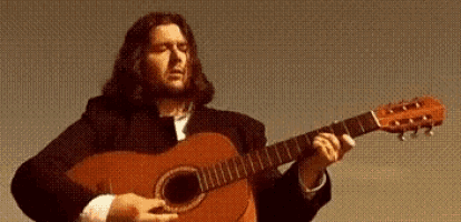 a man with long hair is playing a red guitar
