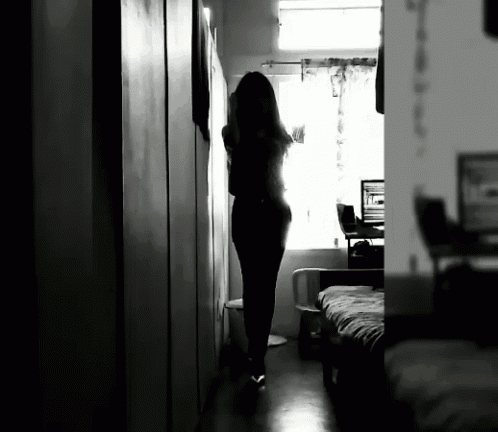 a black and white photo of a woman in a hallway