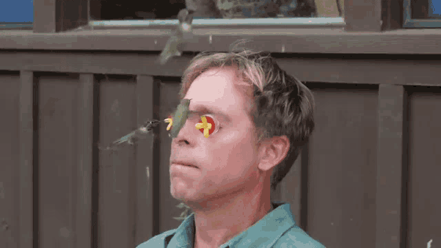 a man with a hummingbird on his face