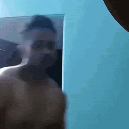 a man without a shirt is standing in a doorway