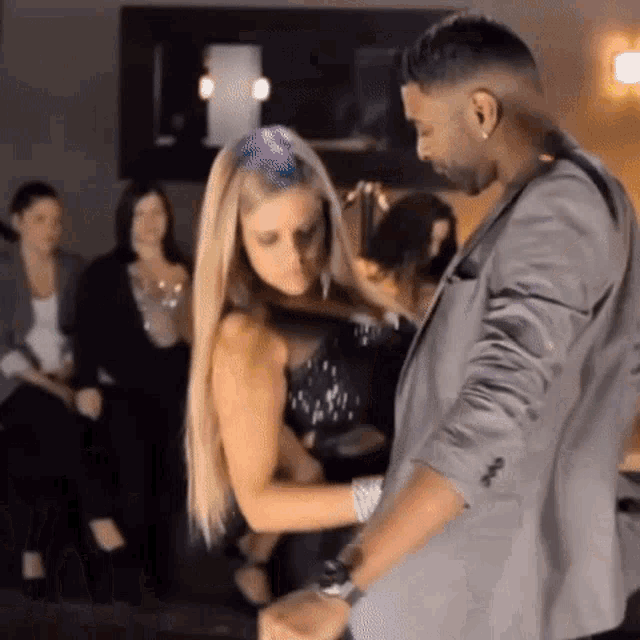 a man and a woman are dancing in front of a crowd .