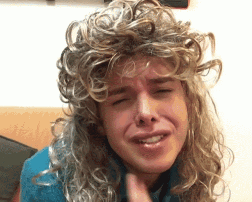 a man wearing a wig is making a face