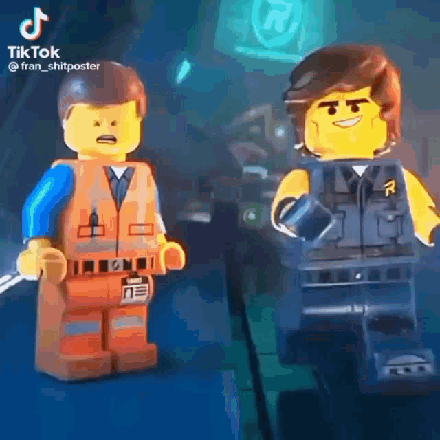 a couple of lego figures are standing next to each other on a stage .