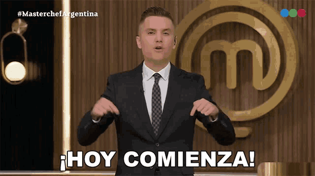 a man in a suit and tie stands in front of a masterchef argentina logo