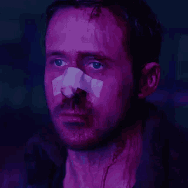 a man with a bandage on his nose looks at the camera .
