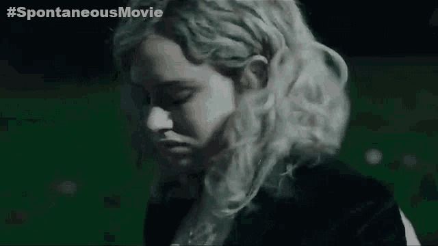 a woman with blonde hair is sticking out her tongue in a dark room .