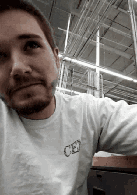 a man with a beard wears a white shirt that says cen