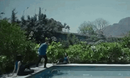 a man and a woman are stretching by a swimming pool .