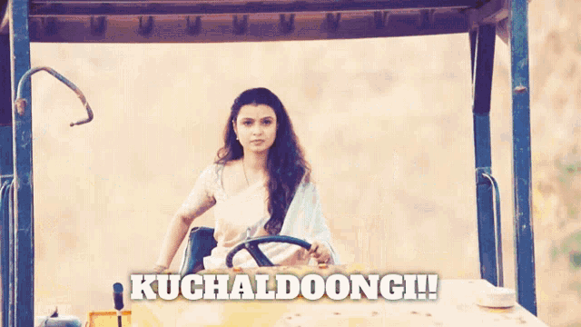 a woman is driving a large yellow vehicle with the words kuchaldoongi written on the bottom