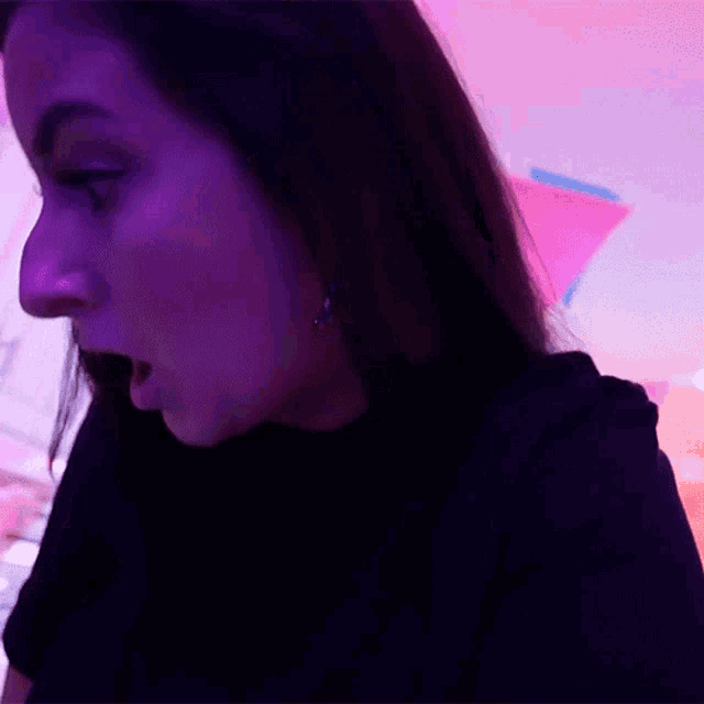 a woman in a black shirt is yawning with her mouth open
