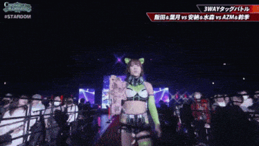 a female wrestler is walking down a red carpet in front of a crowd with the words stardom on the bottom