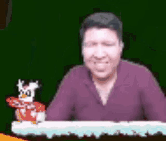 a man in a purple shirt is sitting at a table next to a cartoon character