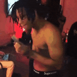a shirtless man with dreadlocks is wearing supreme underwear .