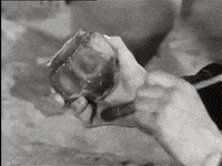 a black and white photo of a person holding a piece of meat in their hands .