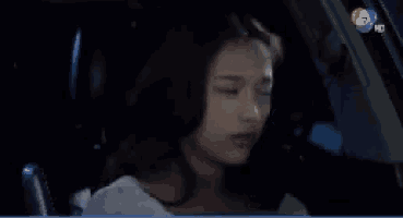 a woman sitting in a car with the number 7 on the bottom right