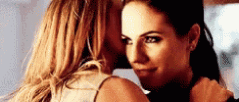 two women are hugging each other and kissing each other on the cheek .