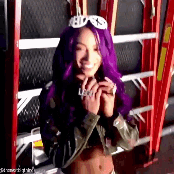 a woman with purple hair is smiling and wearing sunglasses and a ring