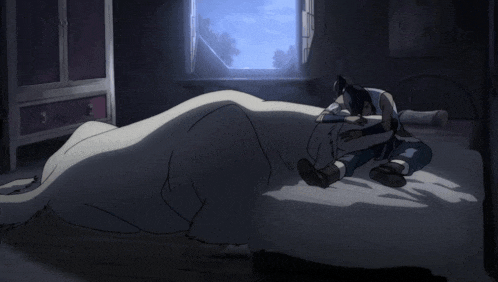 a person laying on a bed with a white blanket on it