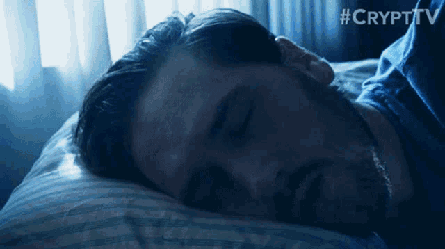 a man is sleeping in a bed with the hashtag #crypttv on the bottom