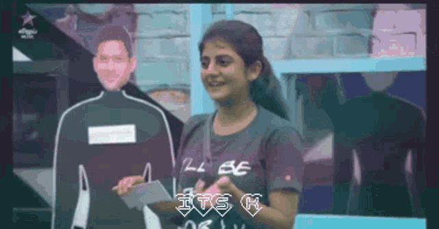 a woman wearing a t-shirt that says " i 'll be " stands in front of a cardboard cutout