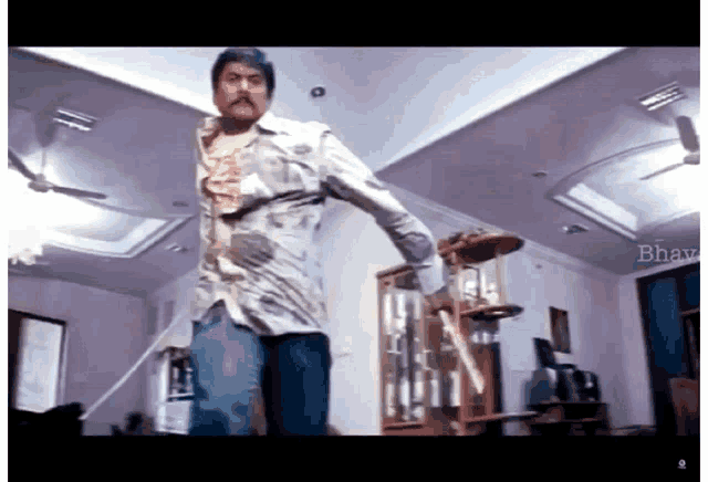 a man in a dirty shirt is standing in a room with the word bharat on the bottom right