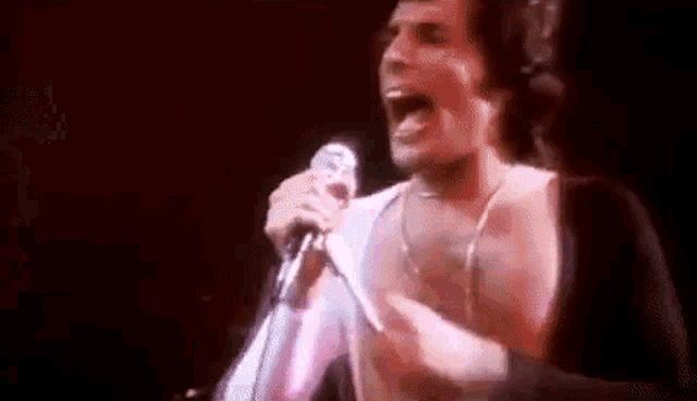 a man is singing into a microphone on stage .
