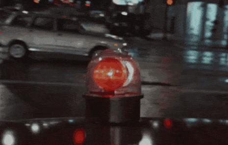 a red light with a car in the background is lit up