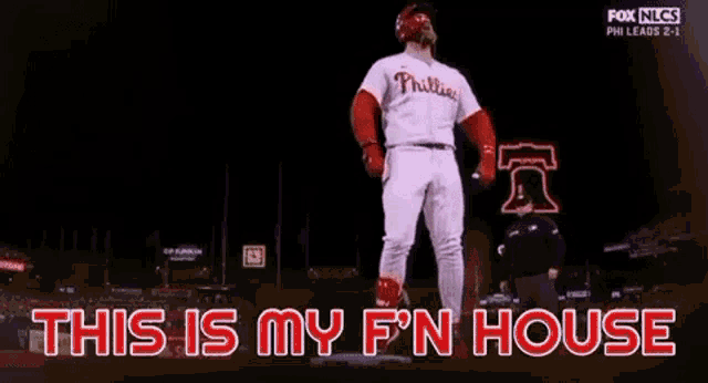a phillies baseball player is standing on a base with the words this is my f n house behind him .