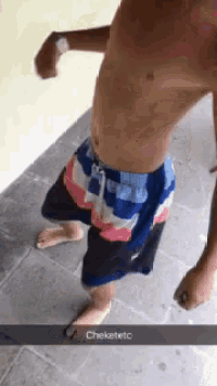 a man without a shirt is standing on a tiled floor with the word cheketeto on the bottom right corner