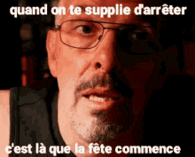 a man wearing glasses and a black tank top says quand on te supplie