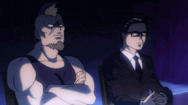 a man with a mohawk sits next to another man in a suit and tie