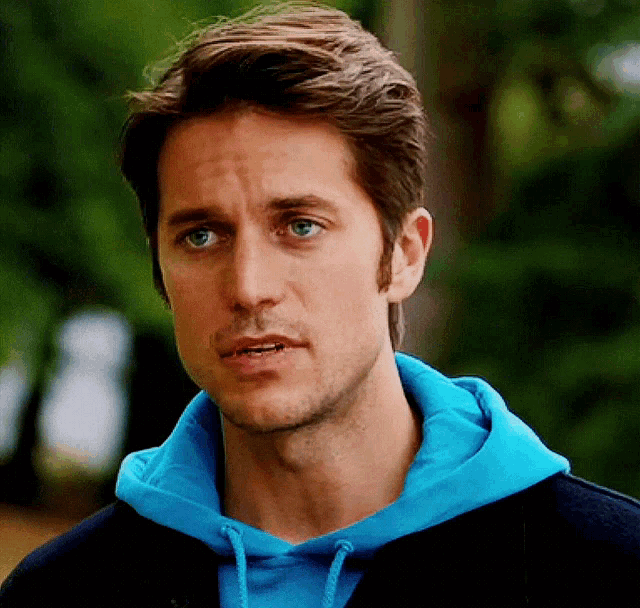 a close up of a man wearing a blue sweatshirt