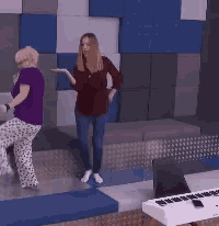 a woman in a purple shirt that says mazda is dancing next to another woman