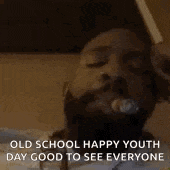 a man with a beard is laying in bed with his eyes closed .