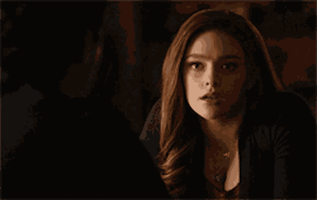 a woman with long red hair is looking at a man .