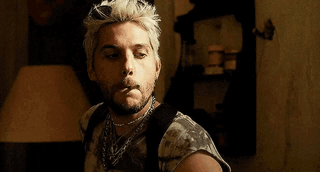 a man with white hair and a beard is smoking a cigarette .