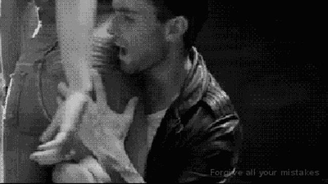 a black and white photo of a man kissing a woman 's foot .