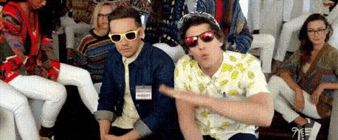 a group of people are sitting on a couch and one of them is wearing sunglasses .